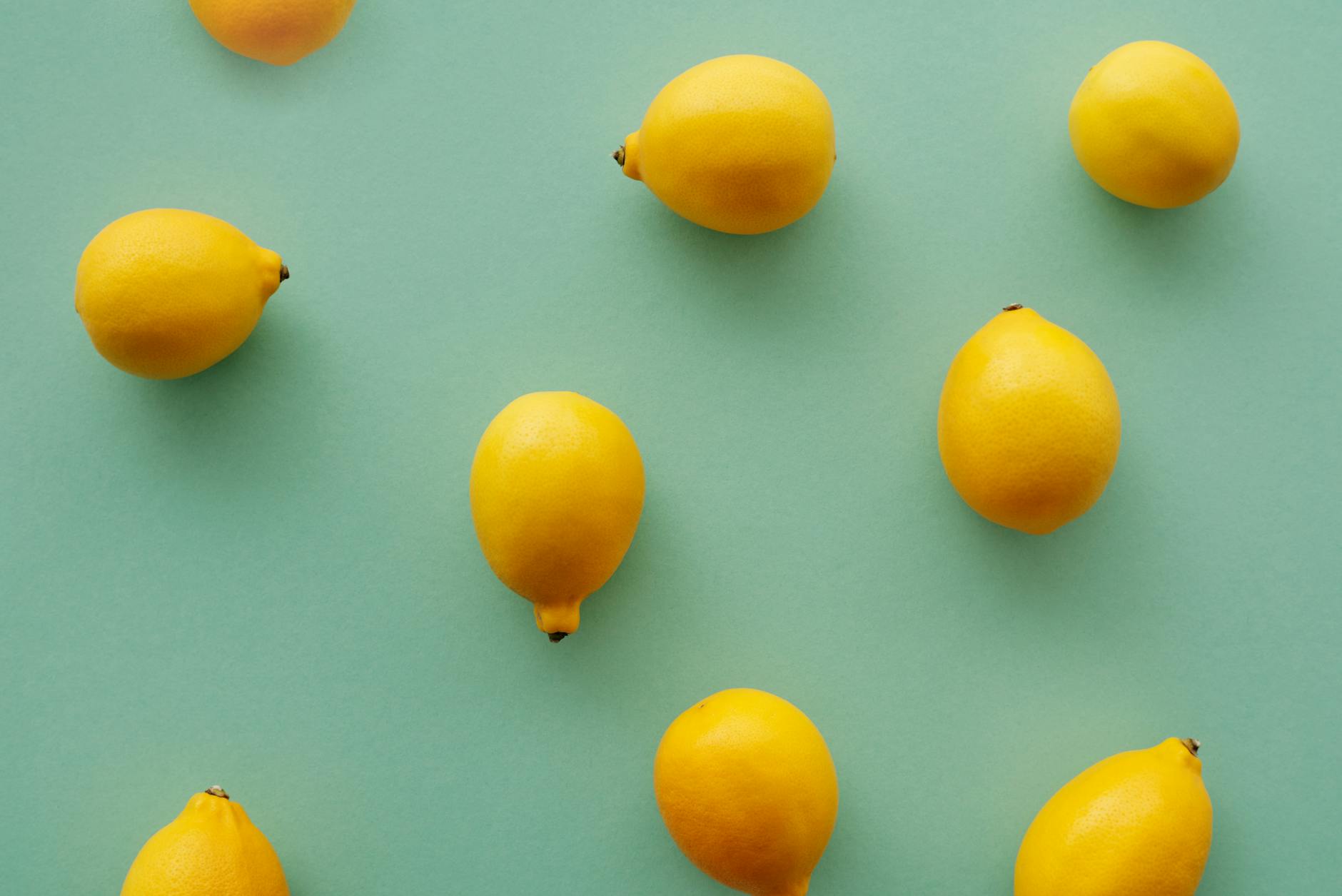 Bright yellow lemons arranged on a pastel green background, symbolizing revival and freshness