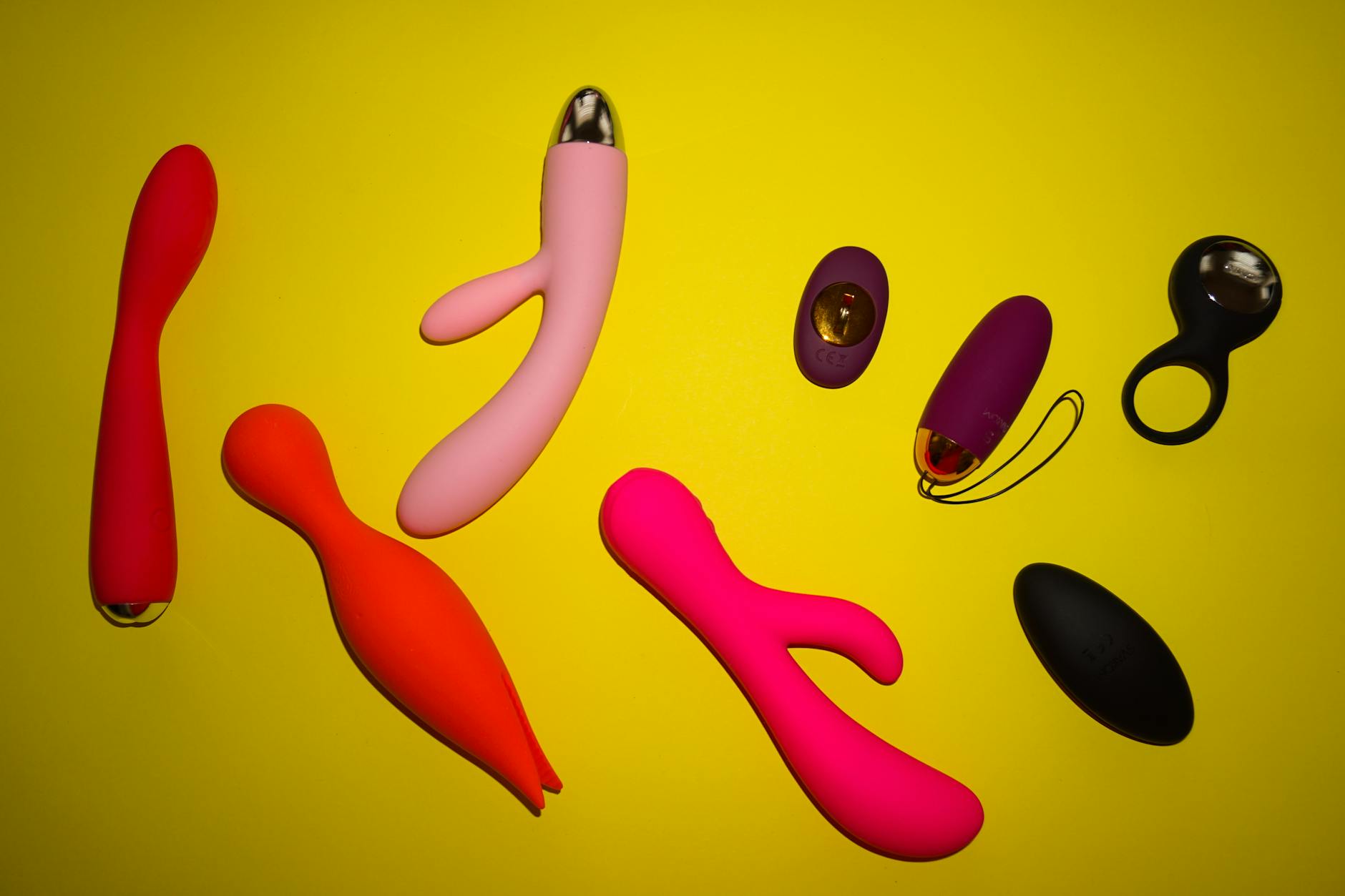 Colorful lemon vibrators and adult toys arranged on a bright yellow surface