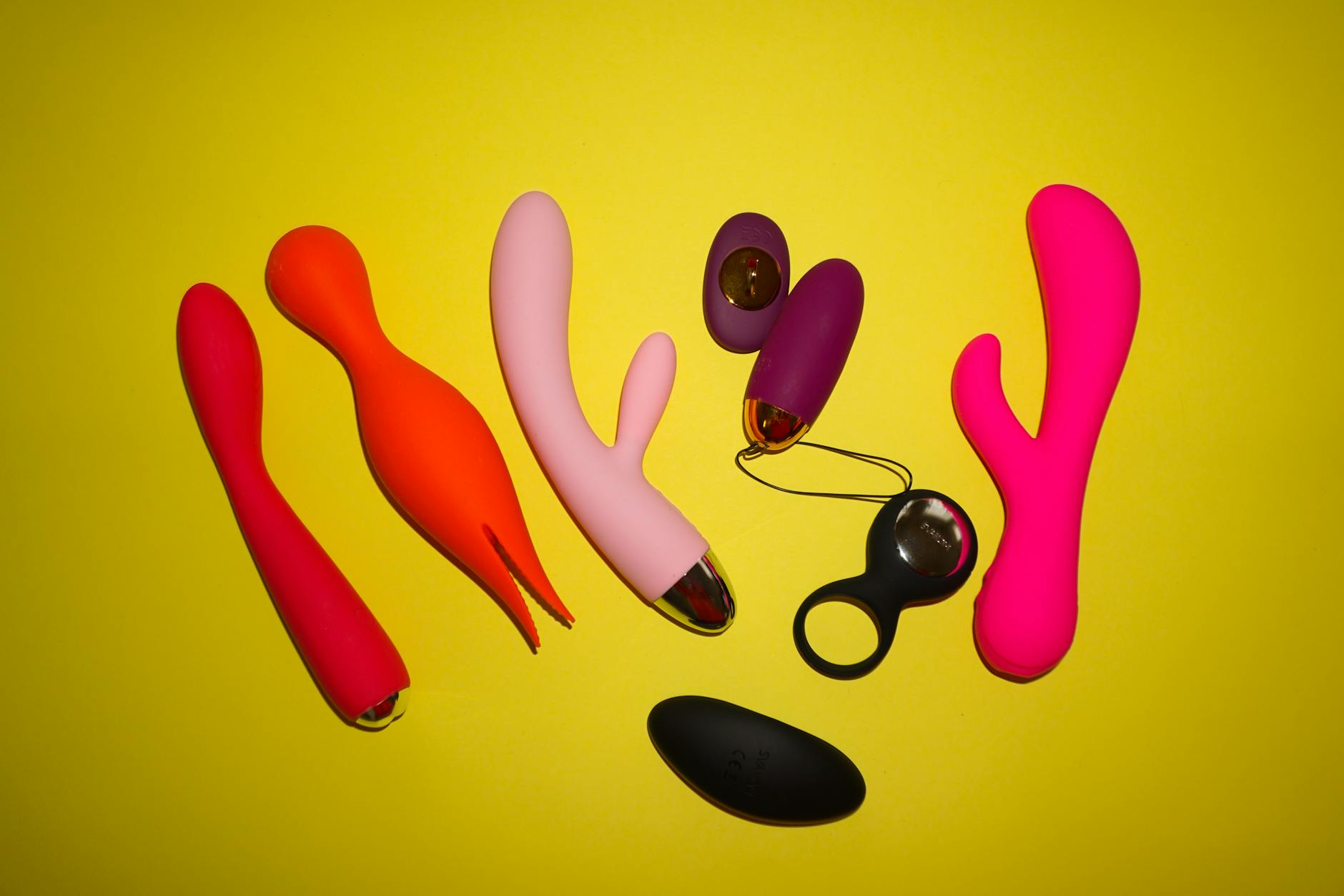 Colorful vibrators on a bright yellow background showcasing different textures and shapes